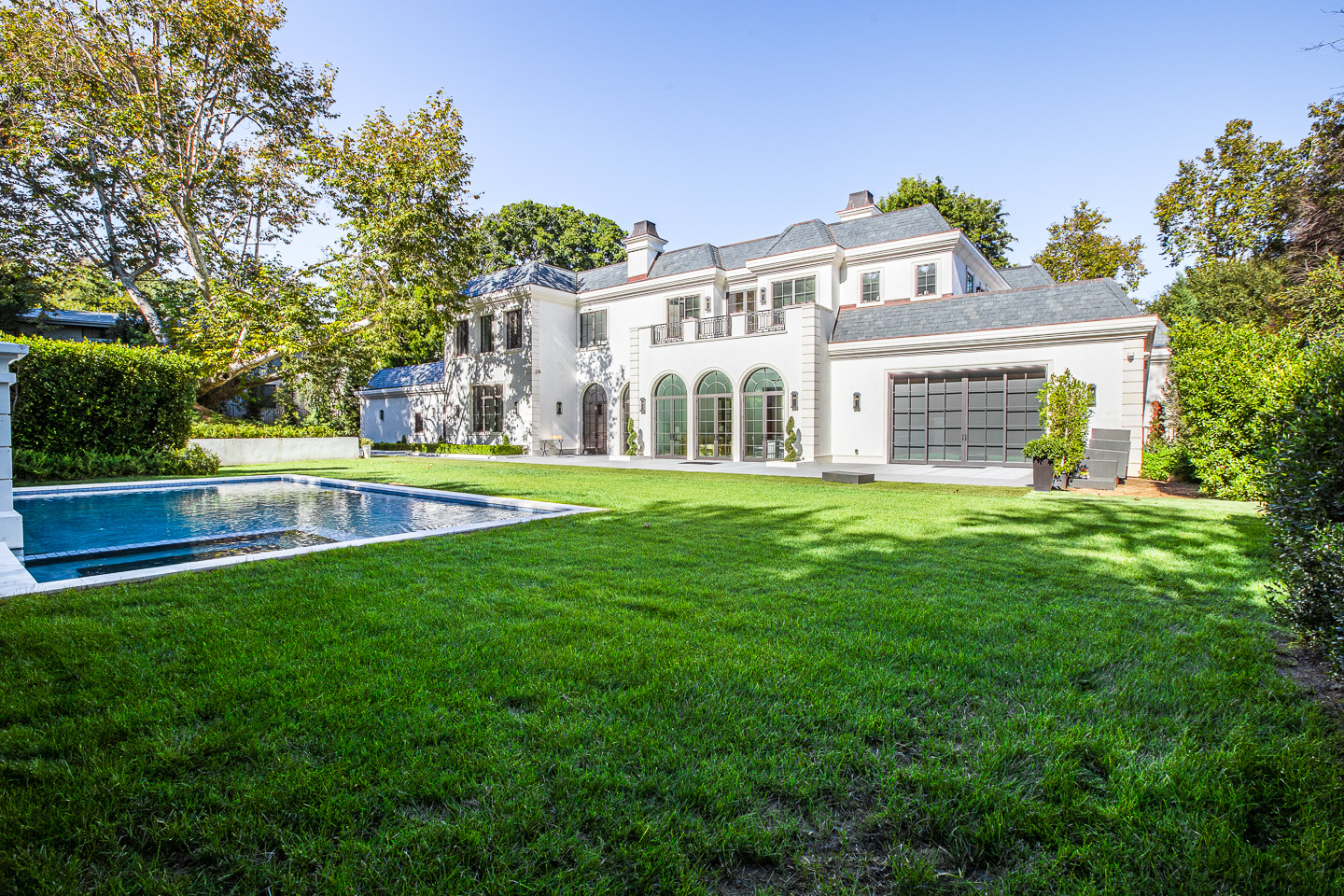 Luxury Los Angeles private estate rental featuring a resort-style pool, manicured lawn, and elegant contemporary residence for corporate events and private celebrations.