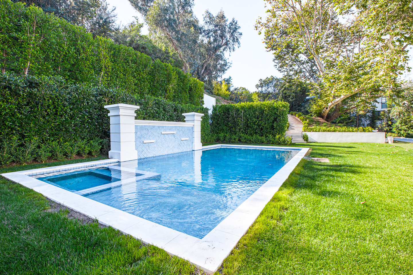 Private resort-style swimming pool surrounded by manicured landscaping at a luxury Los Angeles estate rental.