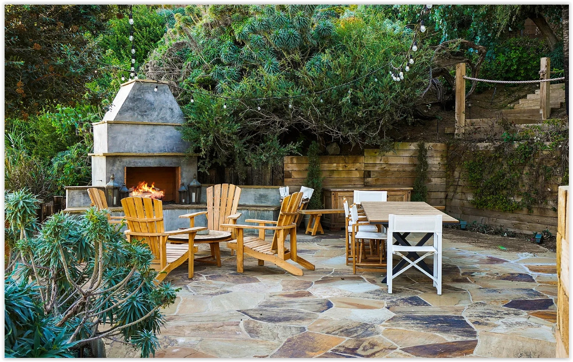 Elegant patio with an outdoor fireplace overlooking the Pacific Ocean at a Malibu private estate.