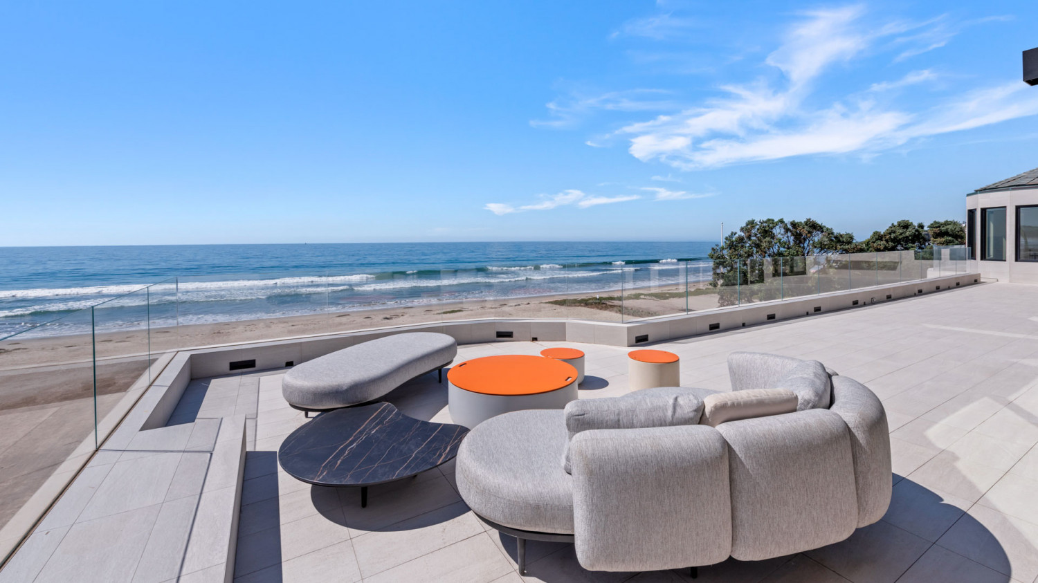 Spacious pool deck overlooking the Pacific Ocean at a modern Malibu beachfront estate.