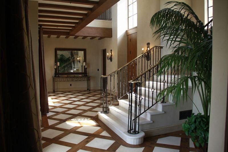Grand entry foyer with sweeping staircase inside a luxury Malibu vineyard estate.