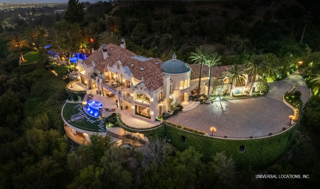 Luxury Mediterranean estate overlooking Los Angeles with panoramic city views, resort-style pool, illuminated terraces, and elegant Spanish-inspired architecture.