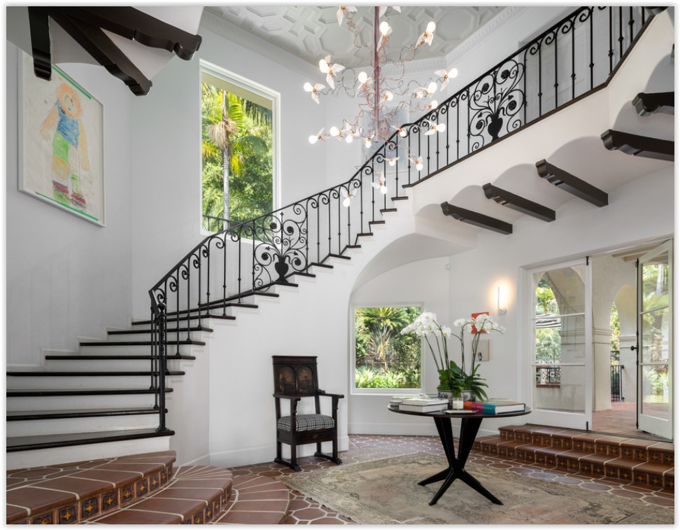 Grand foyer featuring a sweeping staircase, vaulted ceiling, and elegant architectural details inside a Los Feliz private estate.