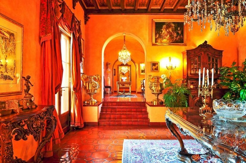 Formal reception room featuring terracotta floors, crystal chandeliers, handcrafted wood ceilings, and antique architectural details