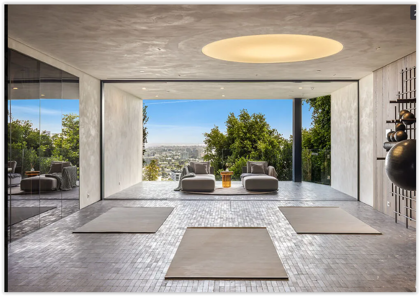 Private wellness studio with floor-to-ceiling glass and panoramic city views inside a luxury Los Angeles estate.