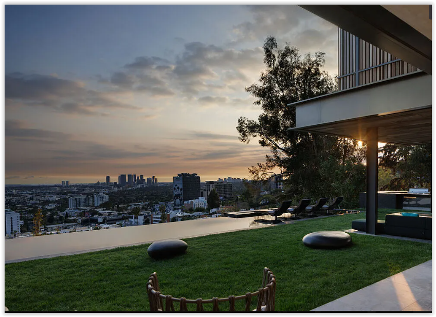 Panoramic sunset views of the Los Angeles skyline from the outdoor living spaces of a modern hillside estate.