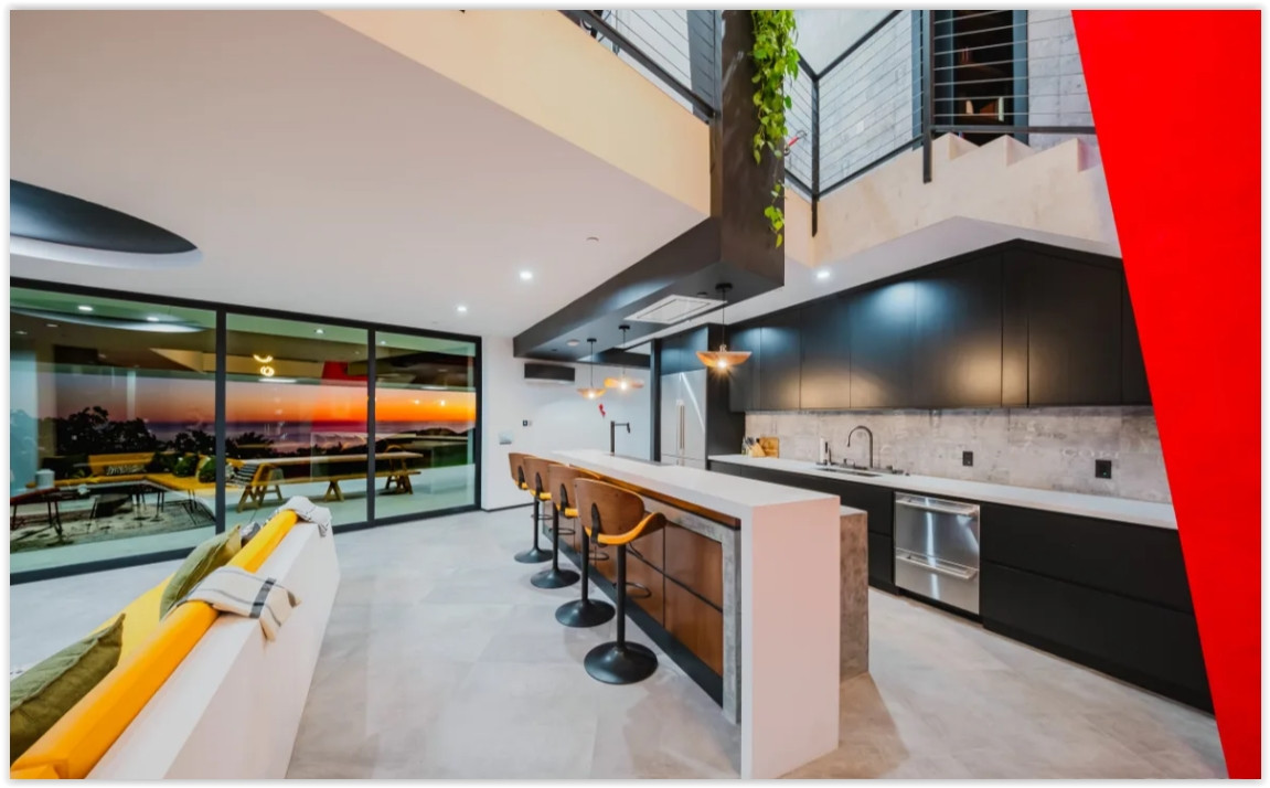 Modern gourmet kitchen with oversized island, custom cabinetry, and seamless indoor-outdoor living in a unique Malibu home.