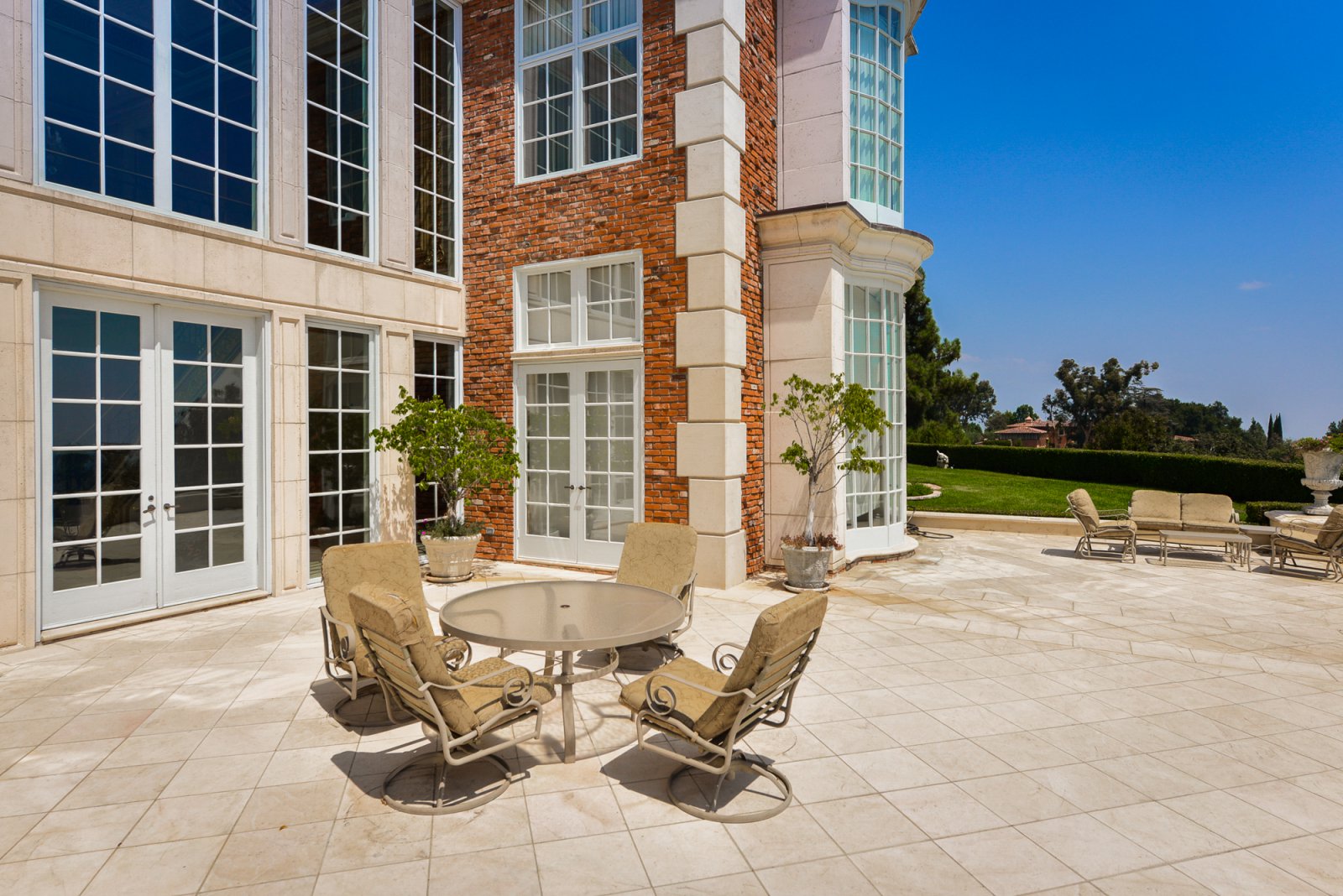 Stone patio with seating overlooking the landscaped grounds of a private Pasadena estate.