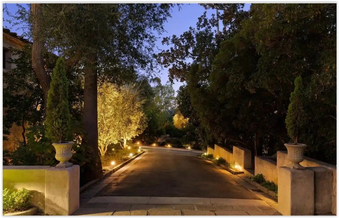 Private tree-lined driveway leading to a secluded Spanish Colonial estate.