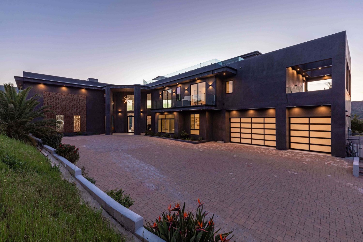 Contemporary hillside estate in Agoura Hills with dramatic modern architecture and illuminated exterior at dusk.