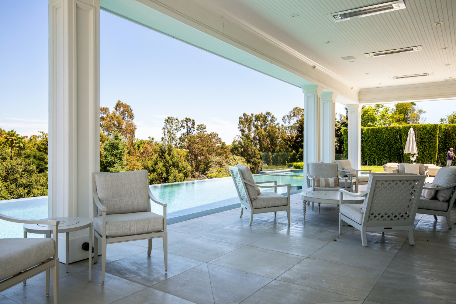 Covered outdoor terrace overlooking an infinity pool and lush landscape at a Modern Private Estate Home Events venue in Los Angeles.