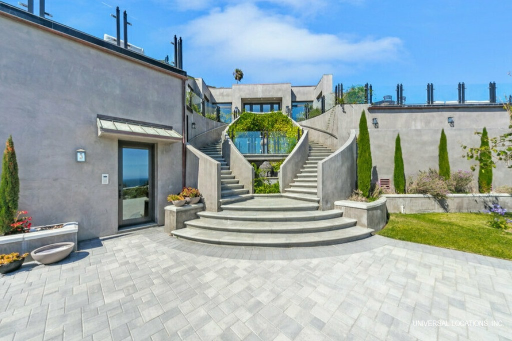 Elegant entrance courtyard with sweeping staircases at a luxury Malibu ocean view estate.